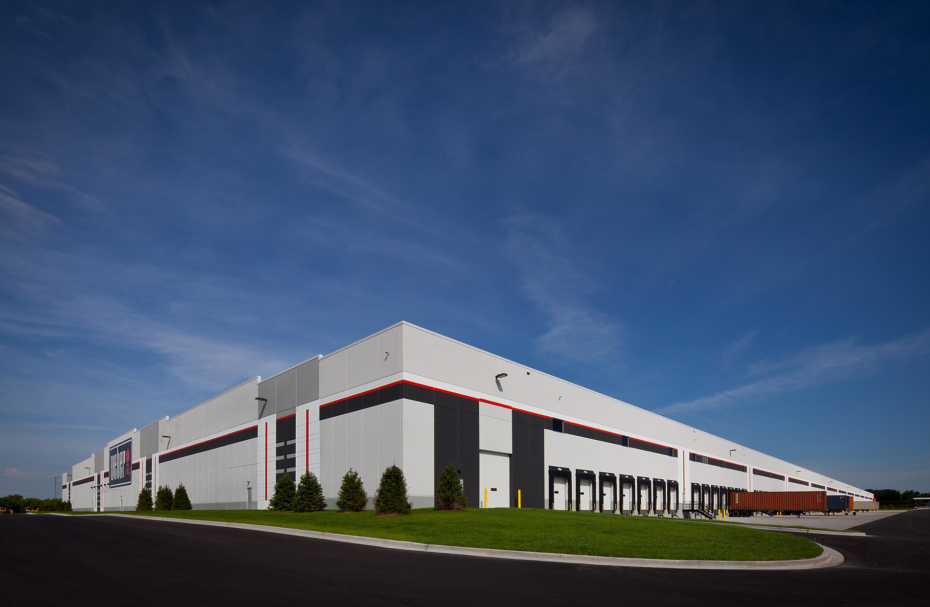 A view of the Weber-Stephen Distribution Facility showcasing it's massive size, loading docks, and tall windows.