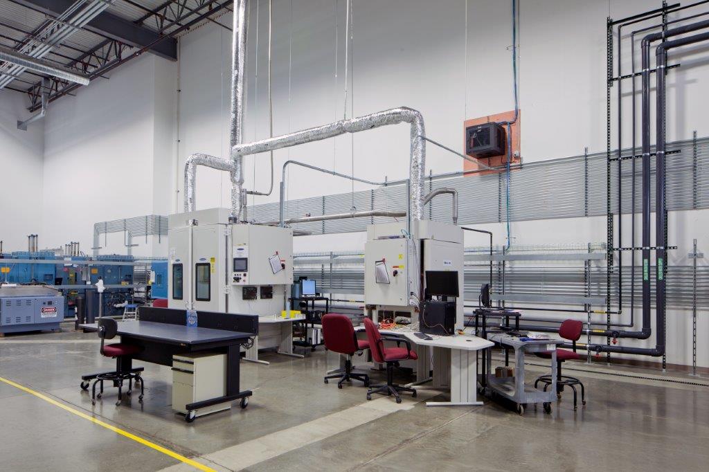 National Technical Systems’ large lab spaces contain large testing equipment, work desks, and chairs. Pipes and other lab equipment line the walls. Keeley Construction was crucial in the renovation and rebuilding of the corporate interiors.