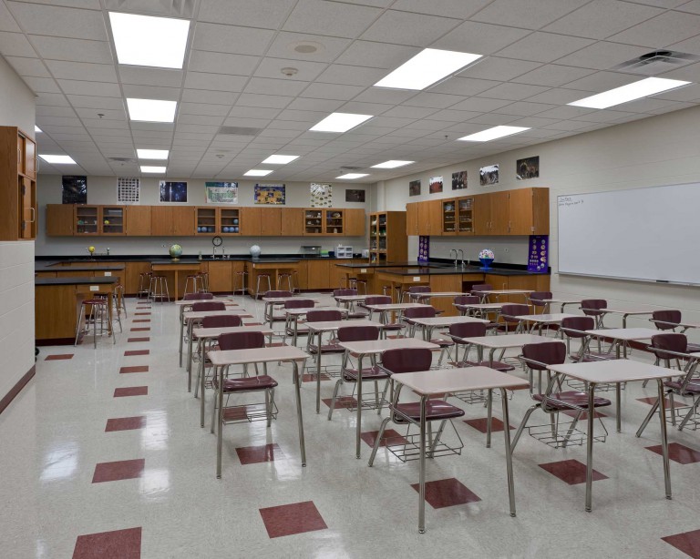 The clean and spacious new science lab in Montini Catholic High School contains rows of desks and chairs with a back wall of cabinets and counters.