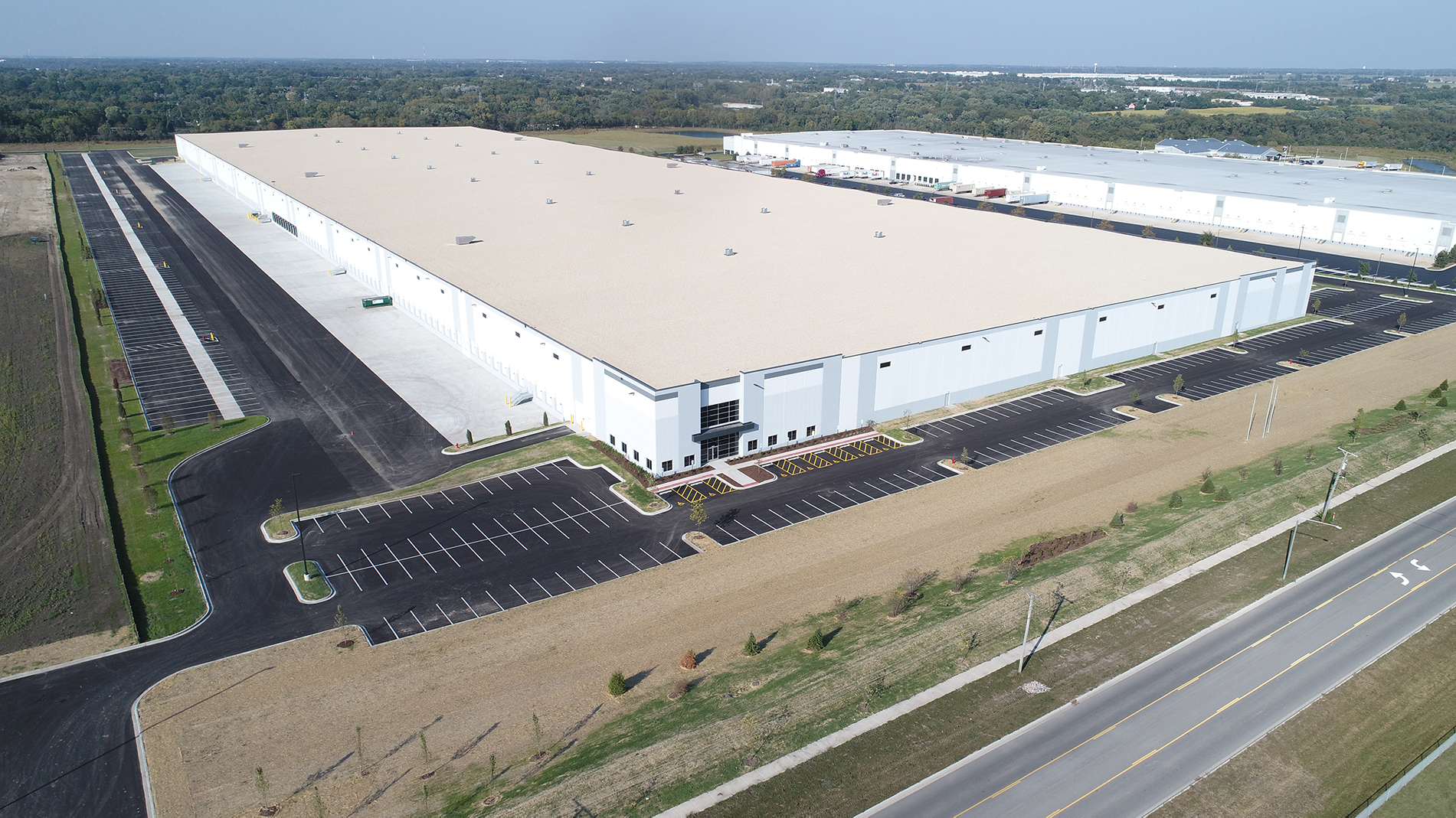 A 1 million square foot warehouse with white walls and a white roof is seen from above.