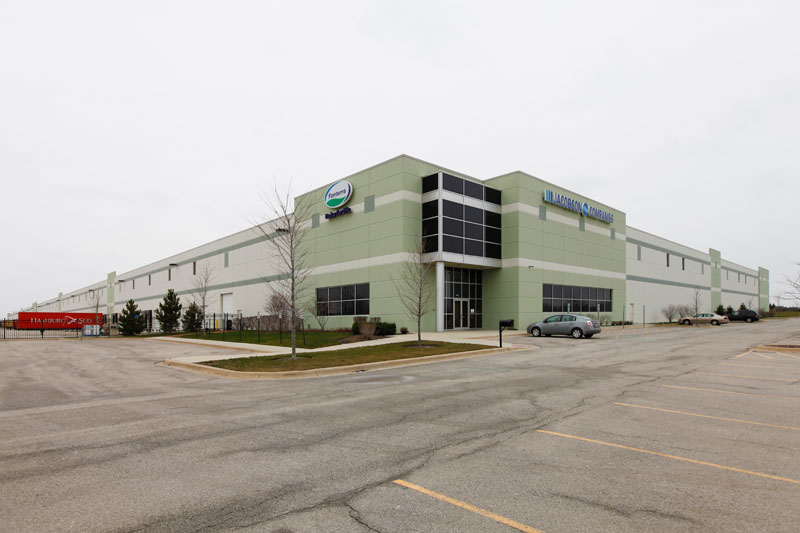 The large exterior of the Jacobson Companies’ food-grade warehouse and office facility sits against a grey sky on an empty parking lot.