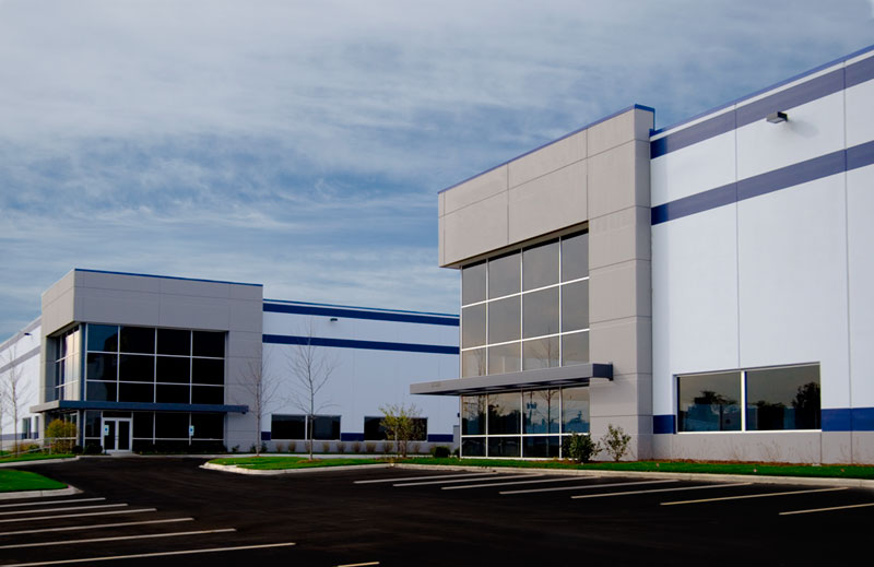 Two almost identical modern buildings, each with a wall of darkened windows at the entrance, sit side by side in the O’Hare East Business Park.