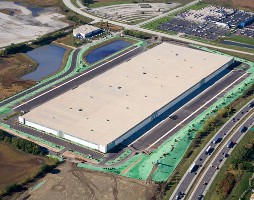 A bird’s eye view of M Block & Sons' new building is a large rectangle surrounded by re-graded landscapes, parking lots, and ponds.