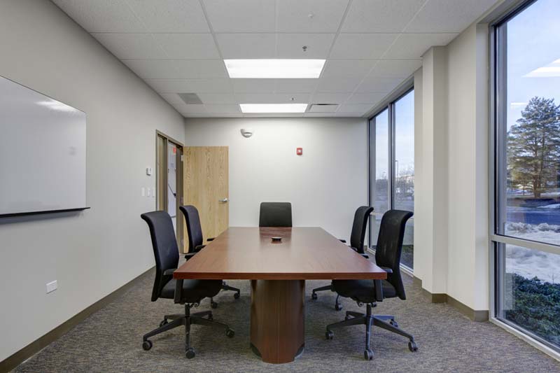 A long conference room accommodates a long table and chairs. The right wall is full of windows, allowing the Wesco room to be flooded with light. Keeley Construction was pivotal in the upgrades to this large building.