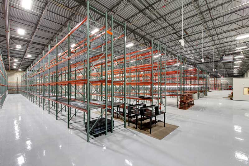 Wesco's cavernous and well-lit warehouse with shiny floors and floor-to-ceiling rows of empty metal shelves.