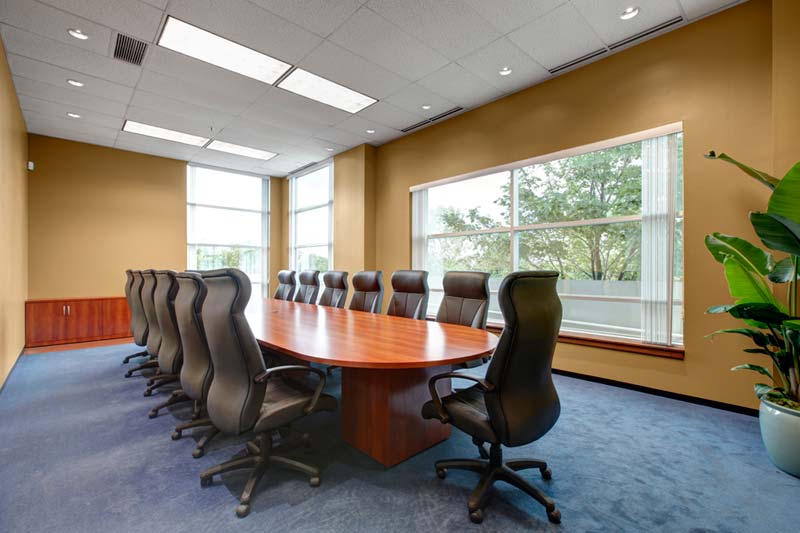 Zones' renovated conference room has a long table with chairs and a large window.