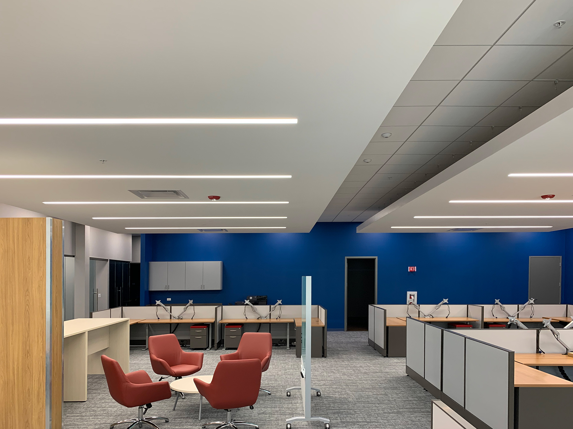 An office space in CODA with four chairs in a circle and open concept, low-walled cubicles placed along the outer walls.