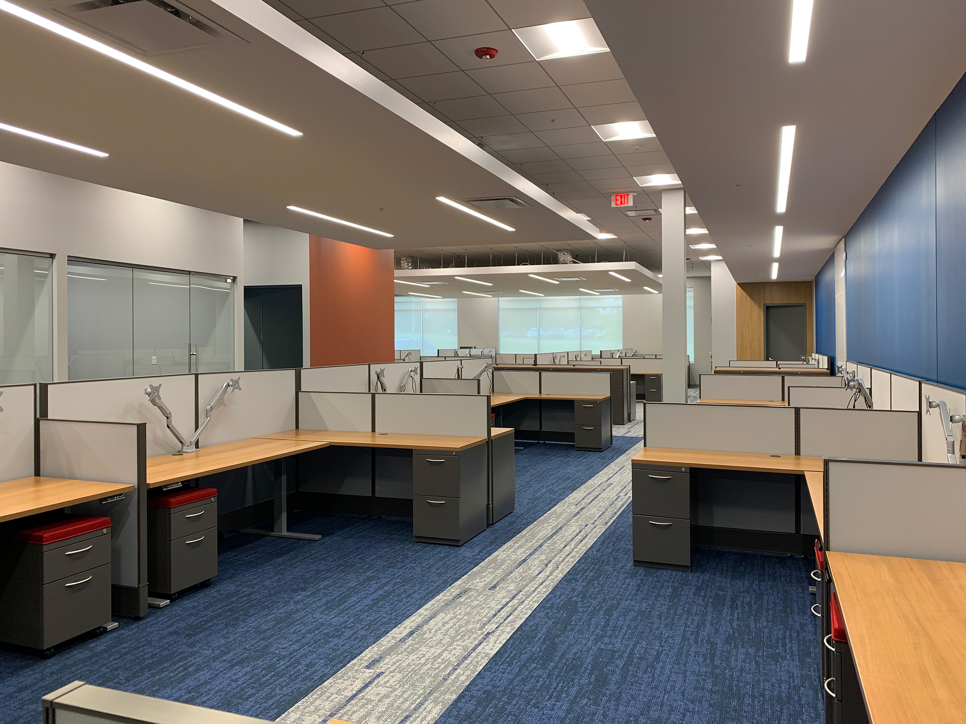 A long view of a room containing modernized cubicles and workspaces.