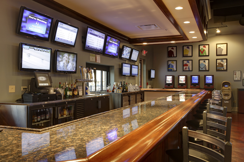 A bar with a polished marble counter and multiple monitors on the back wall was part of the new building constructed by Keeley Construction, Inc.