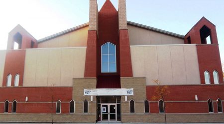 The red brick exterior of the Greater Open Door Community Church in Illinois stands against a blue sky.